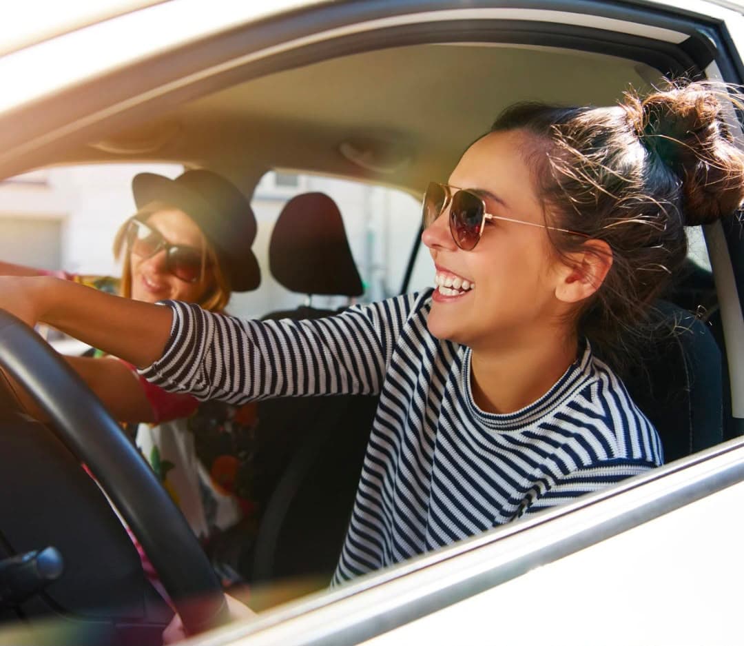 Women in a car smiling
